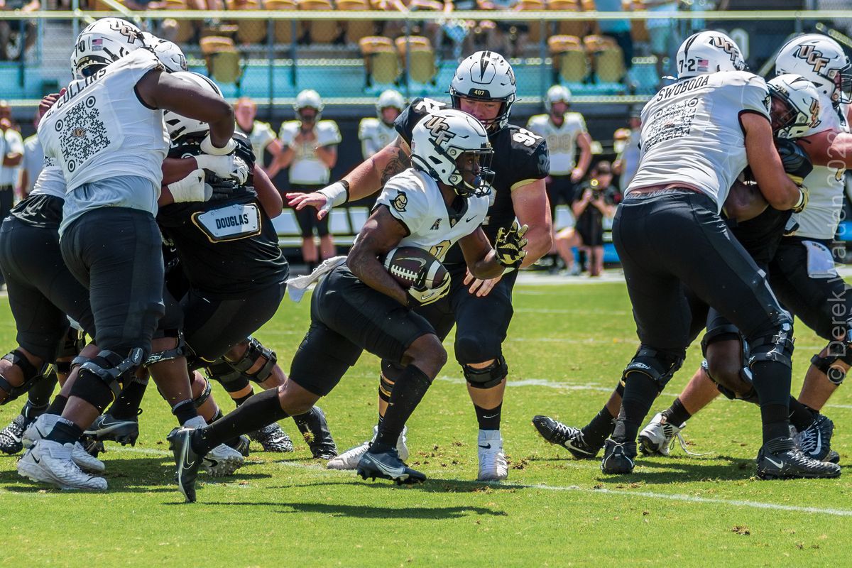 Johnny Richardson carries the ball against the defense in the spring game.