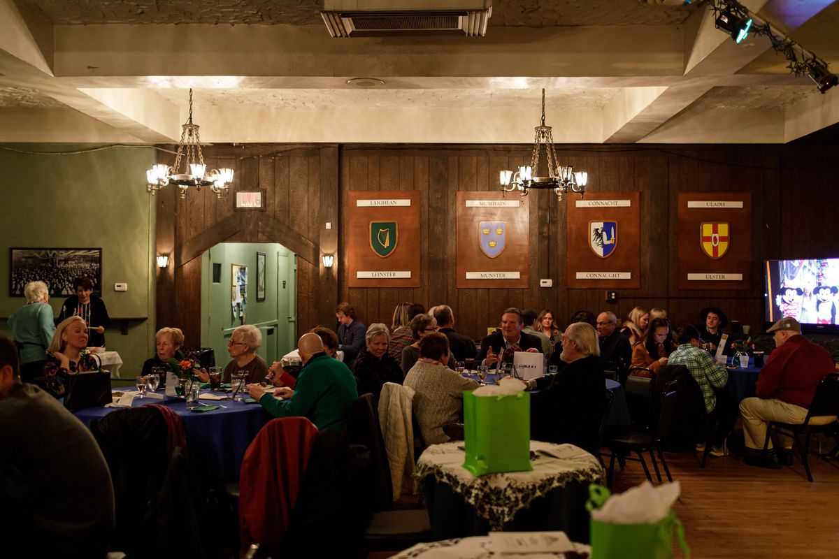 People gather inside the wood-paneled annex at the Gaelic League. 