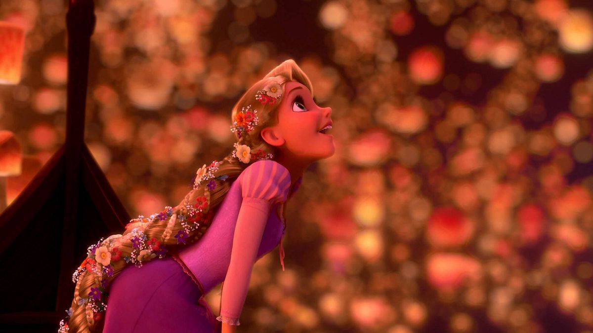 Rapunzel in Tangled leans out of a boat, looking with delight at the colored floating lanterns all around her