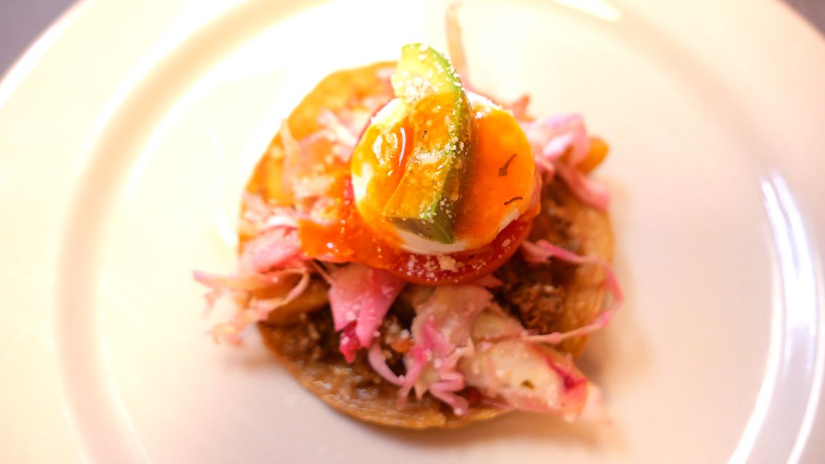 A dish made with a tostada, different ingredients