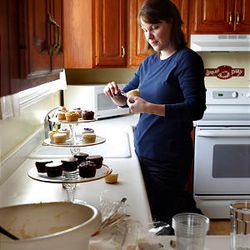 Elizabeth Plehn decorates cupcakes in her Sandy home. She bakes, decorates and delivers from home.