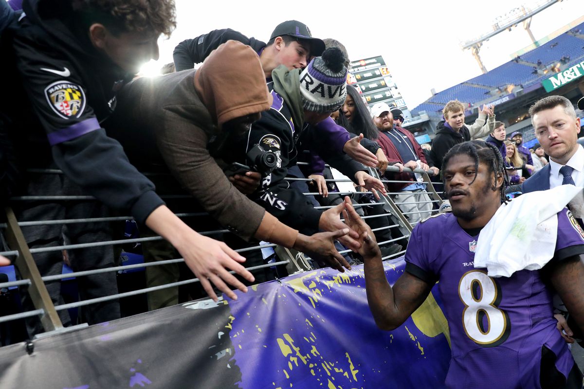 Lamar Jackson #8 of the Baltimore Ravens high fives with fans after their overtime win against the Minnesota Vikings at M&amp;T Bank Stadium on November 07, 2021 in Baltimore, Maryland.