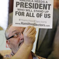 A person holds a sign as Utah's six presidential electors prepare to cast their votes for President-elect Donald Trump, Monday, Dec. 19, 2016, in Salt Lake City. The electors, who were chosen by Utah GOP delegates earlier in the year, cast their votes in a brief meeting Monday at the state Capitol as protesters filled the room, yelling "Vote your conscience," and "The whole world is watching."