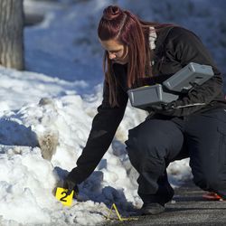 A forensics officer prepares an area of a drive-by shooting crime scene for photo documentation in Kearns on Wednesday, Dec. 28, 2016. Police were called to 5285 W. Stockton Ave. about 2:30 p.m. and reported a 9-year-old was hit in the head and was taken from the scene in critical condition.