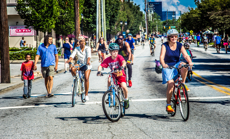 A picture of people biking on a crowded howell mill road.