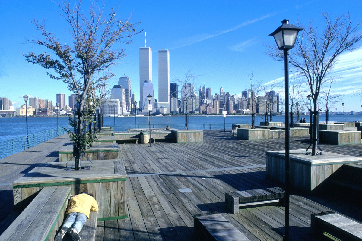 Person lying on bench on pier overlookin