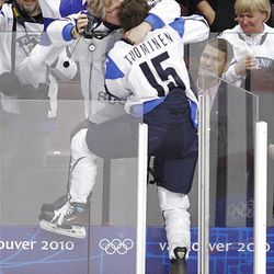 Finland's Minnamari Tuominen climbs the glass to get a kiss after Finland beat Sweden 3-2 in overtime in the women's bronze medal ice hockey game at the Vancouver 2010 Olympics in Vancouver, British Columbia, Thursday.