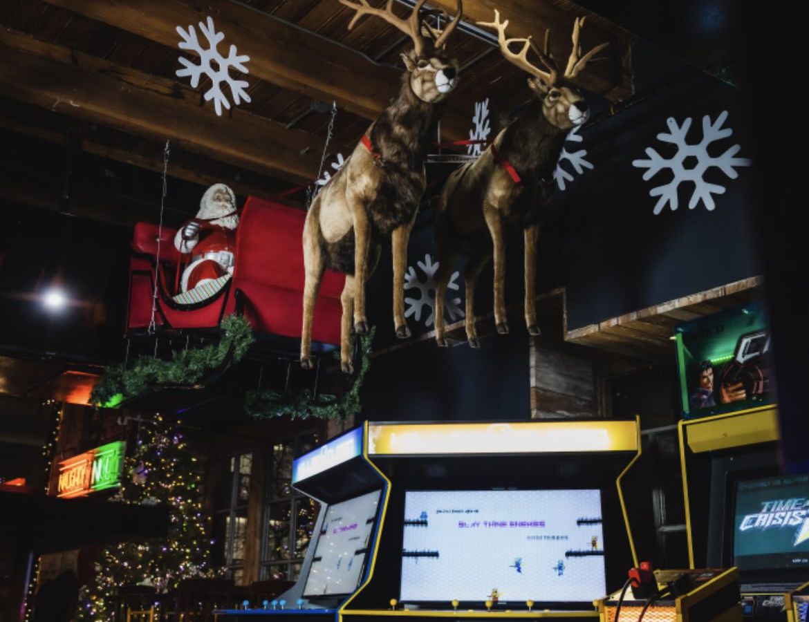 Santa’s sled drawn by two reindeer hangs over arcade machines