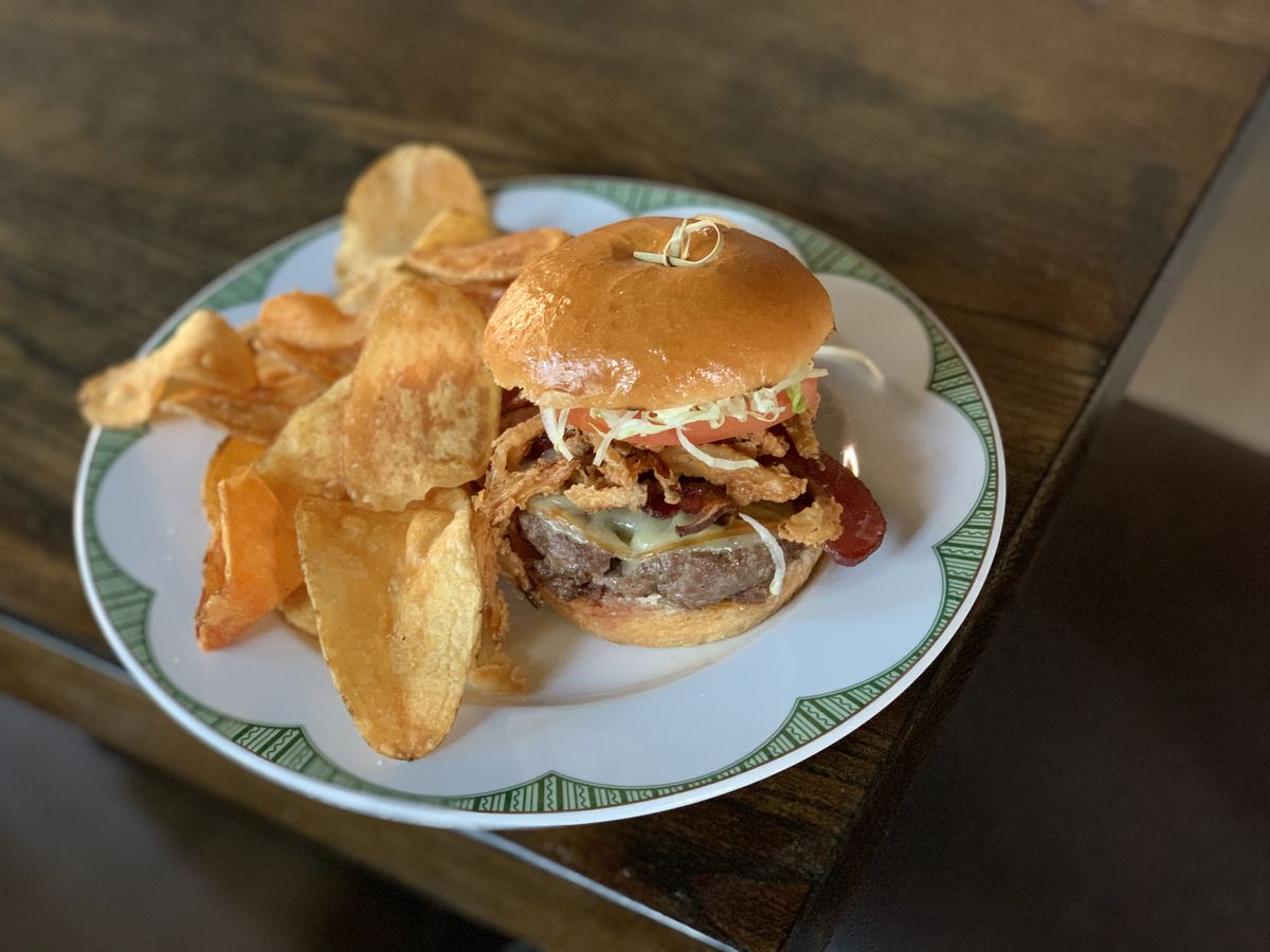 The burger at Augie’s, topped with crispy onions, gouda and horseradish aioli.