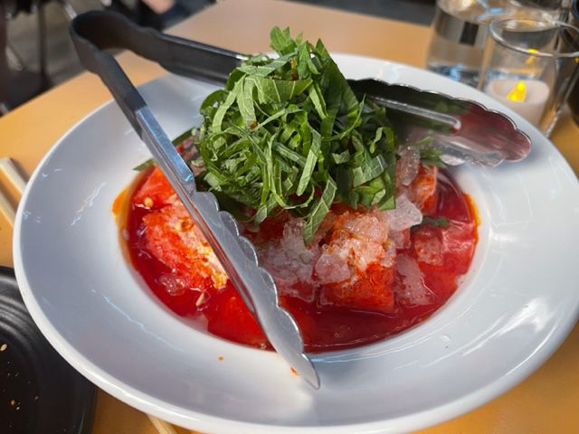 Spicy watermelon salad with chiles garnished with basil in a chilled bowl