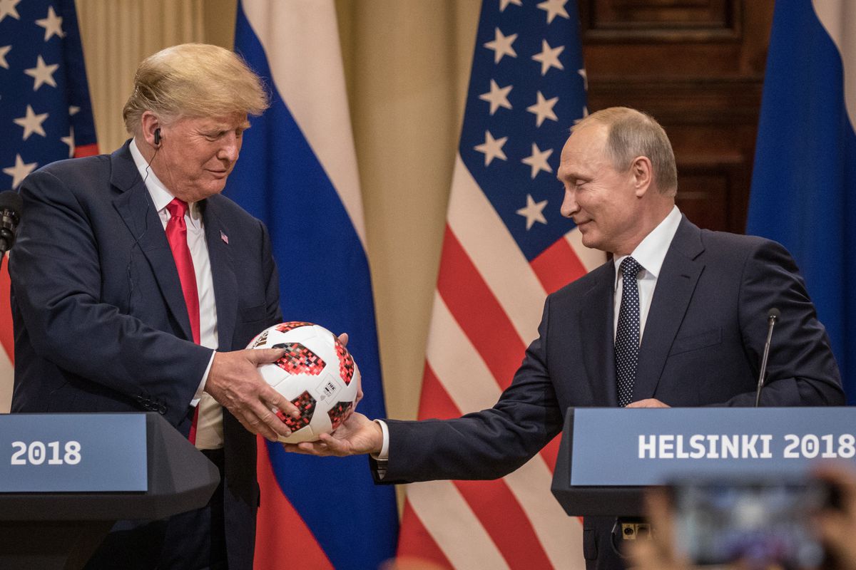 Russian President Vladimir Putin hands US President Donald Trump a World Cup soccer ball during a joint press conference after their summit on July 16, 2018 in Helsinki, Finland.