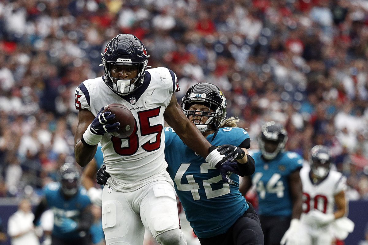 Pharaoh Brown #85 of the Houston Texans runs with the ball after a reception as he pursued by Andrew Wingard #42 of the Jacksonville Jaguars at NRG Stadium on September 12, 2021 in Houston, Texas.
