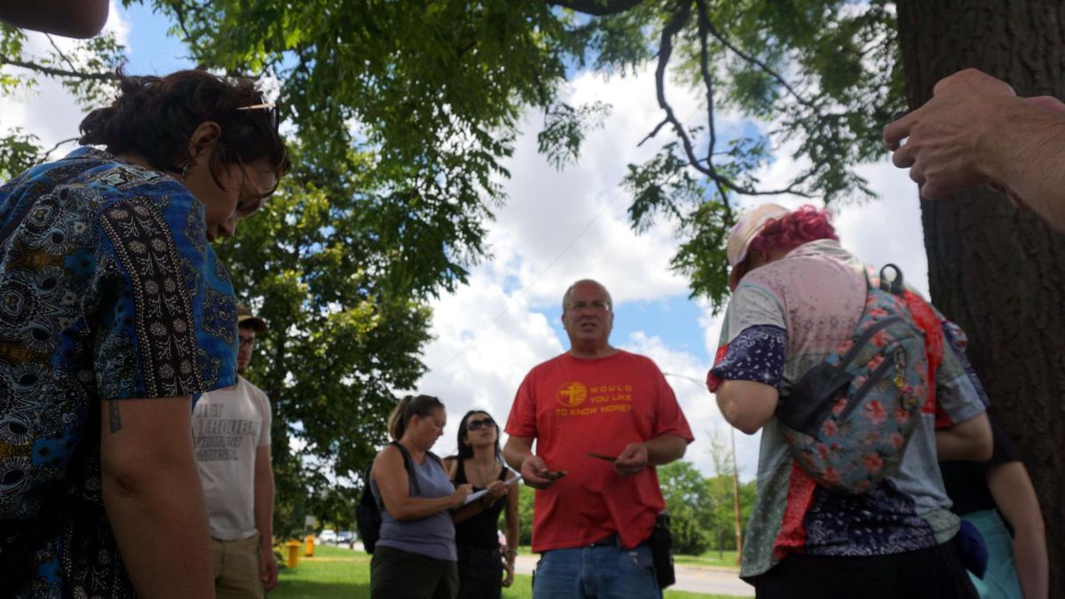 An outdoor tour through Humboldt Park with people chatting with each other outdoors.