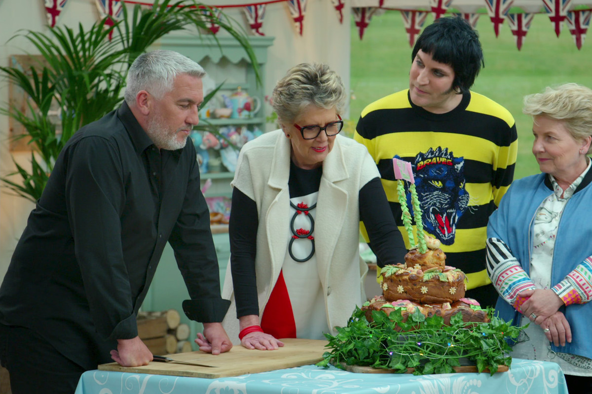 Great British Bake Off’s Paul, Prue, Noel, and Sandi examine a festive bread cake creation. 