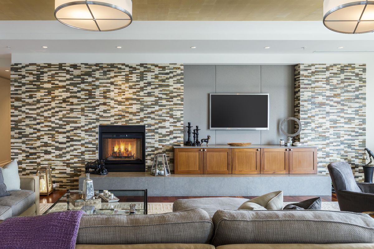 A modern living room with a flat-screen TV on the wall next to a fireplace.