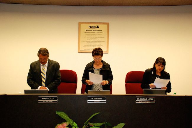 Pueblo City Schools board members Mike Colucci, left, and Kathy DeNiro and Superintendent Maggie Lopez recite the school district’s mission before a school board meeting in April. School officials are confident they’re on the right path to beat the state’s accountability clock.