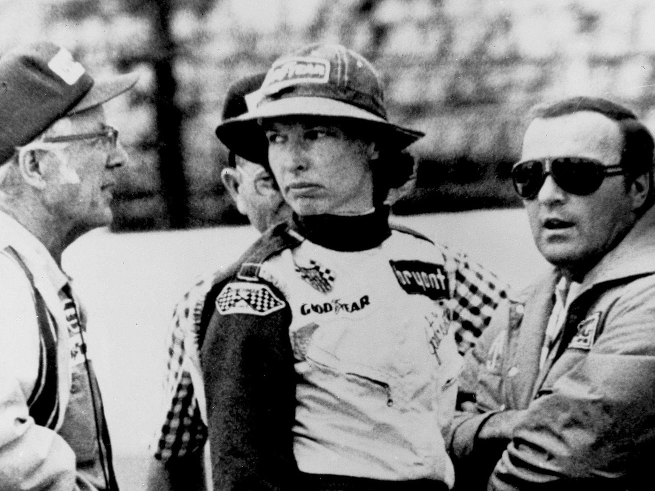 In this May 23, 1976, file photo, Janet Guthrie talks to racing car owner-builder Rolla Vollstedt (left) and A.J. Foyt (right) in the pits of the Indianapolis Motor Speedway, in Indianapolis. 