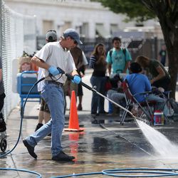 Don Allen, with Advantage Services, sprays down the sidewalk on 500 West in the Rio Grande neighborhood of Salt Lake City on Thursday, July 6, 2017. Many homeless people set up camps in the area, which are periodically cleaned up. While Allen is able to let the water go down the drain this time, sometimes the water is so dirty that it has to be collected afterward.