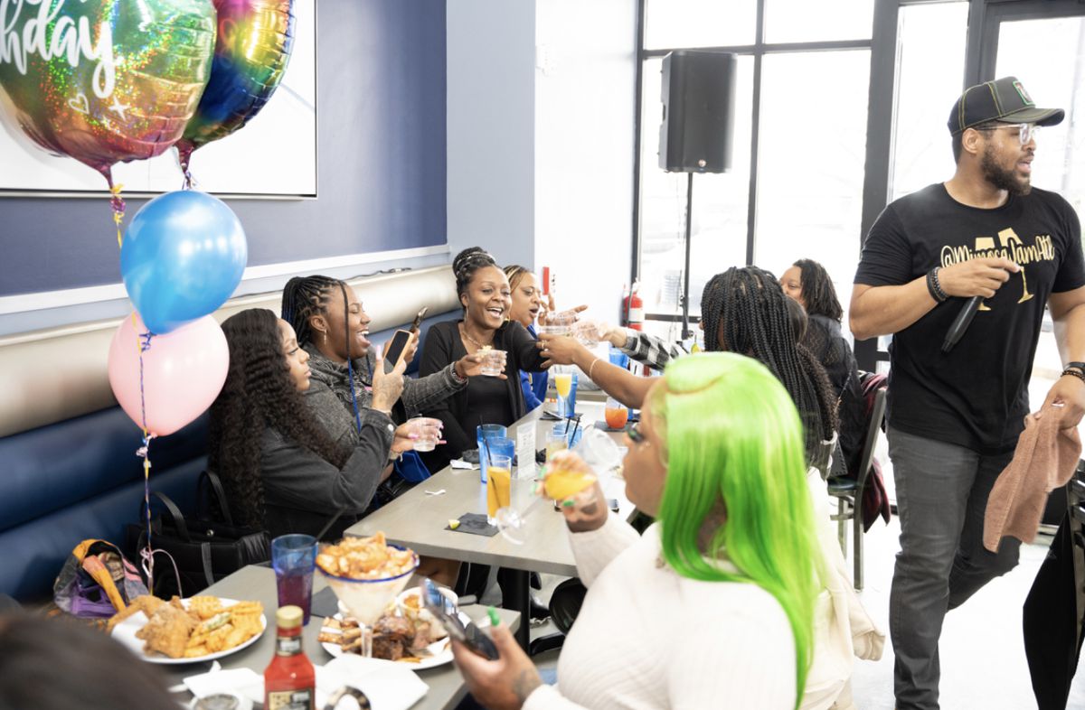A group of Black women friends celebrate and cheers during a birthday brunch at Nouveau Bar and Grill in College Park, GA. 