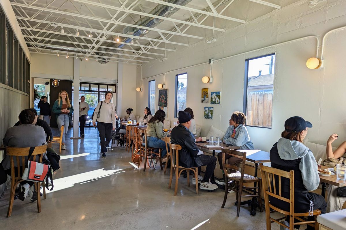 Diners sit around a minimalist French cafe space of Mangette.