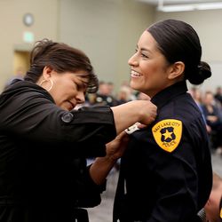 Esthela Flores pins a badge on her daughter, officer Amy Novoa, during a Salt Lake City Police Department Academy graduation ceremony at the Pioneer Precinct in Salt Lake City on Friday, March 4, 2016. Fifteen Salt Lake police and two fire department recruits spent 23 weeks training in the police academy. Beginning Monday, the new officers will embark on 15 weeks of field training with veteran officers in order to be certified for solo patrol work. 