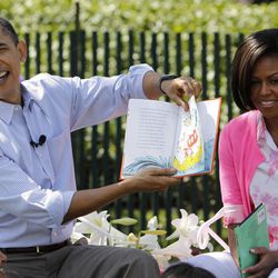 FILE - In this April 5, 2010 file photo, President Barack Obama, accompanied by first lady Michelle Obama and daughter Malia Obama, reads "Green Eggs and Ham", as they hosted the annual White House Easter Egg Roll on the South Lawn of the White House in Washington. What does Michelle Obama do next? After eight years as a high-profile advocate against childhood obesity, a sought-after talk show guest, a Democratic power player and a style maven, the first lady will have her pick of options when she leaves the White House next month.