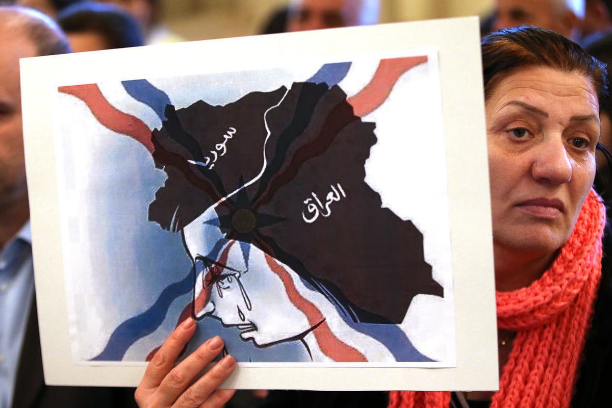 An Iraqi Assyrian woman who fled from Mosul to Lebanon holds a placard depicting the map of Iraq and Syria, during a sit-in for abducted Christians in Syria and Iraq, at a church in Sabtiyesh area east Beirut, Lebanon, Thursday, Feb. 26, 2015. Islamic Sta
