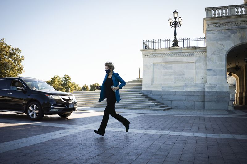 Senator Elizabeth Warren, in her signature all-black clothes topped with a jewel-tone jacket, hurries from the Capitol building.