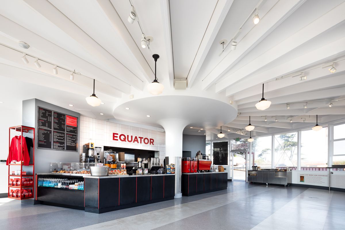 The interior of Equator Coffees at Round House Cafe with white walls and red espresso machines on the counter.  