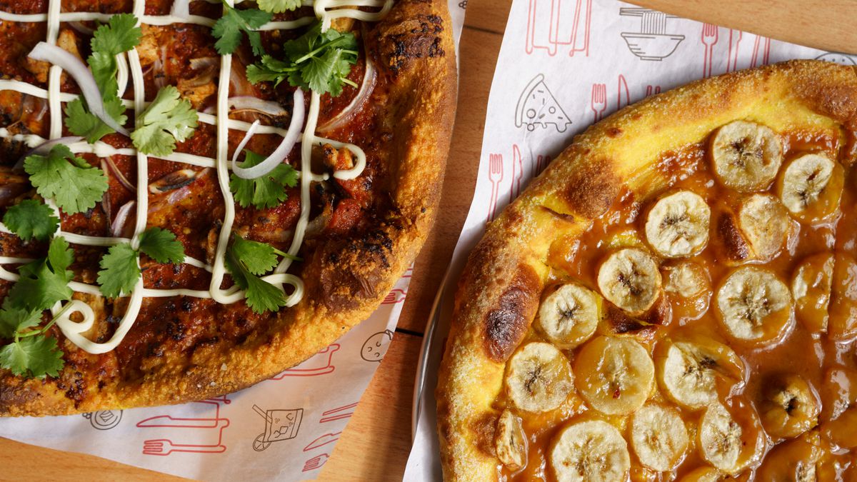 Two pizzas; one tipped with meat, white sauce, and herbs, the other topped with dulce de leche and banana slices. 