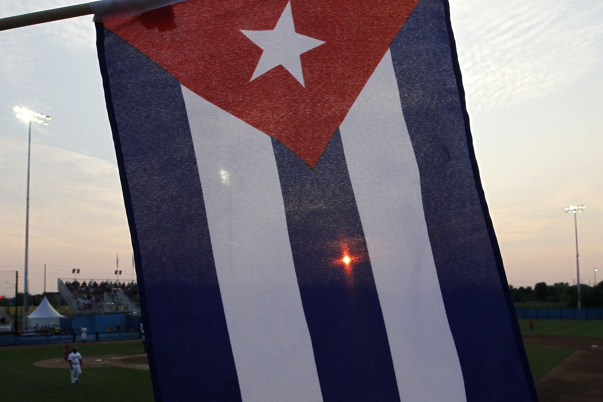 The seting sun is seen through a Cuba flag during their Toronto 2015 Pan Am Games baseball game agai