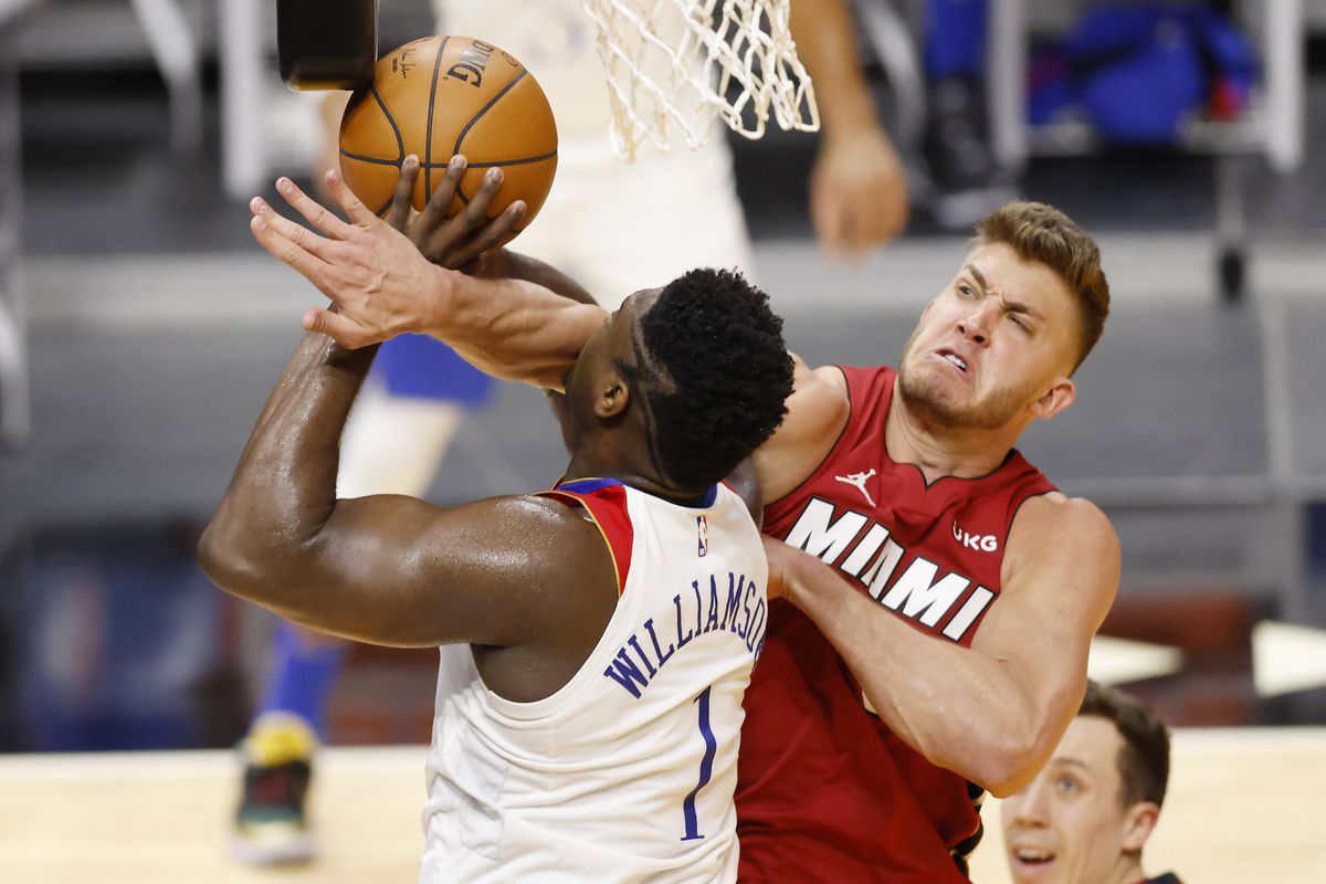 Zion Williamson of the New Orleans Pelicans goes up for a shot at the rim but gets fouled by Meyers Leonard of the Miami Heat