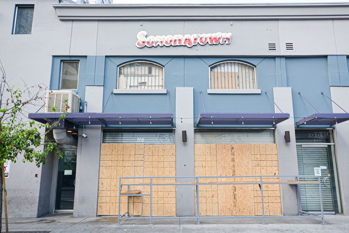 Boarded up windows protect a restaurant in Downtown Los Angeles during protests.