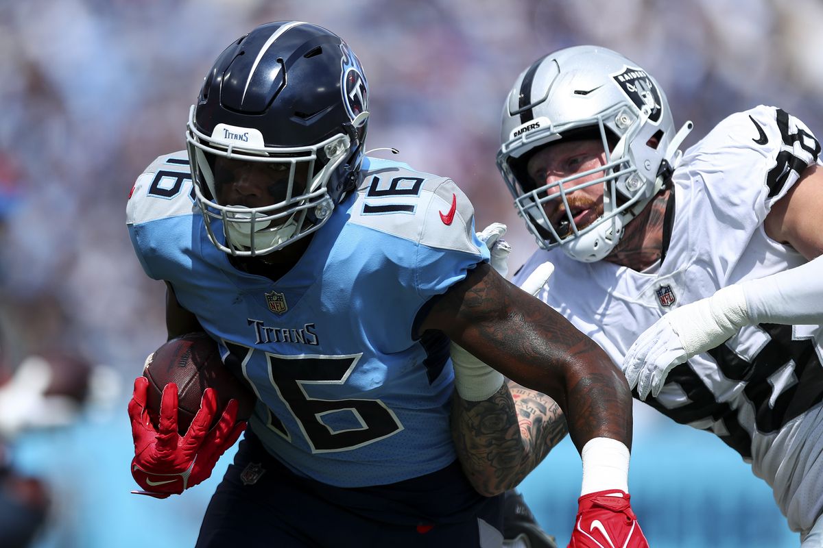 Treylon Burks #16 of the Tennessee Titans carries the ball past Maxx Crosby #98 of the Las Vegas Raiders during an NFL football game at Nissan Stadium on September 25, 2022 in Nashville, Tennessee.