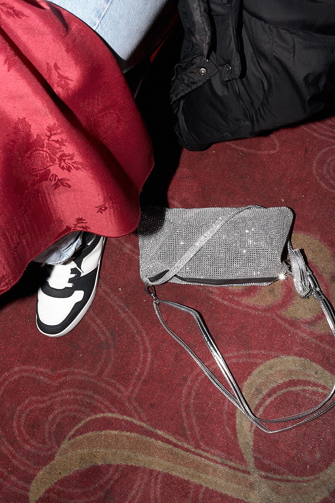 On the red carpet underneath Ceanna’s seat lies her silver rhinestone sparkling Primark handbag.