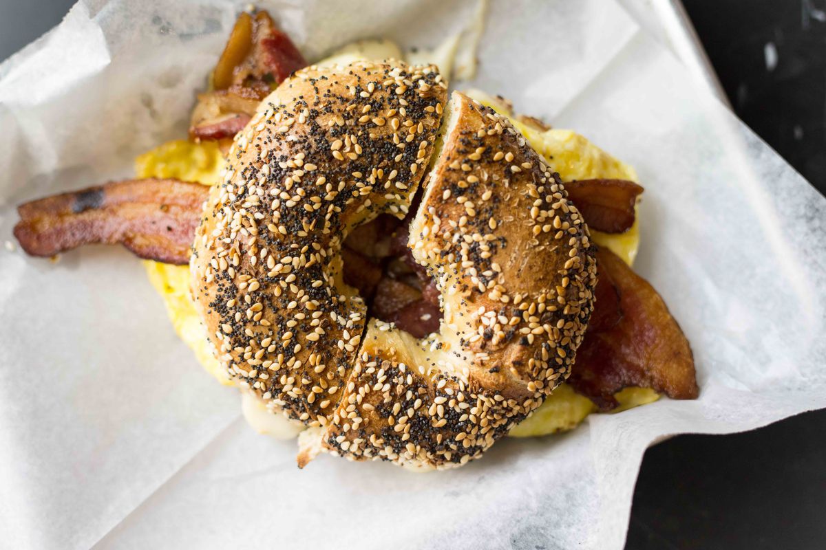 a bagel with bacon and egg on it