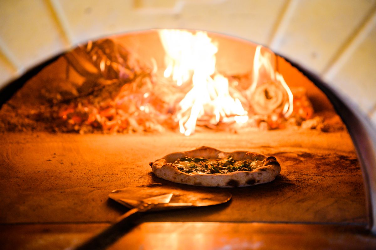 A pizza comes out of the oven at Gracie’s Apizza.