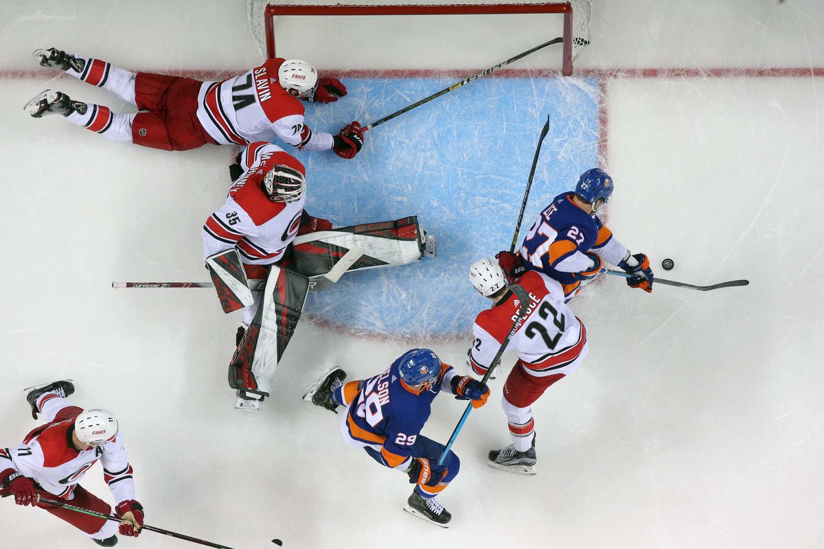 Apr 28, 2019; Brooklyn, NY, USA; New York Islanders left wing Anders Lee (27) shoots against Carolina Hurricanes goalie Curtis McElhinney (35) in front of Carolina Hurricanes defenseman Jaccob Slavin (74) and Carolina Hurricanes defenseman Brett Pesce (22