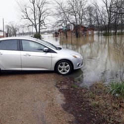 A resident backs her car out of a flooded driveway after the water reached the bottom of her door jam, Friday, March 11, 2016, in Drew, Miss. A number of counties reported various levels of flooding from recent rains which began Wednesday and could last through Saturday. 