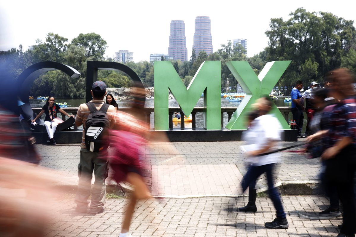 Tourists walk past the CDMX sign, located in the Historic Center of Mexico City.