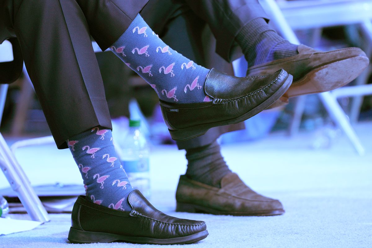 Men’s feet in loafers with colorful socks.