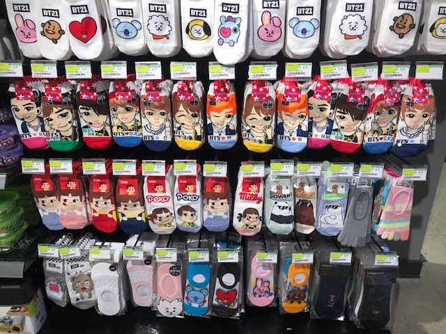 A display of socks that have various cartoon and anime characters on them.