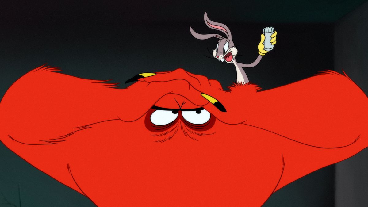 Bugs Bunny stands on the head of Gossamer, the big red monster from Looney Tunes cartoons.