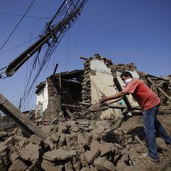 A resident removes the rubble of a destroyed house in Talca, Chile, Feb. 27, 2010, after an 8.8-magnitude struck central Chile. 