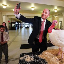 Lt. Gov. Spencer Cox takes a photo with Sir Featherbottoms, a turkey he pardoned during a ceremony at the Capitol in Salt Lake City on Monday, Nov. 21, 2016.