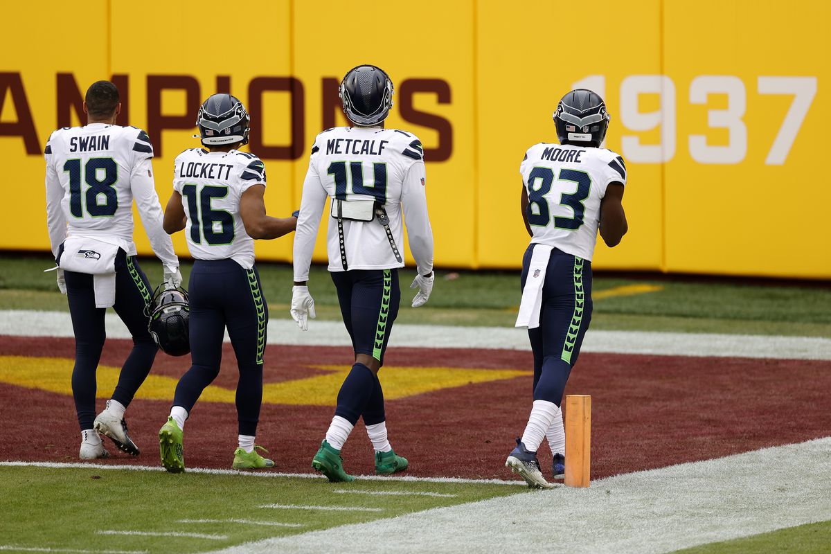 Freddie Swain #18, Tyler Lockett #16, DK Metcalf #14, and David Moore #83 of the Seattle Seahawks warm up before the start of their game against the Washington Football Team at FedExField on December 20, 2020 in Landover, Maryland.
