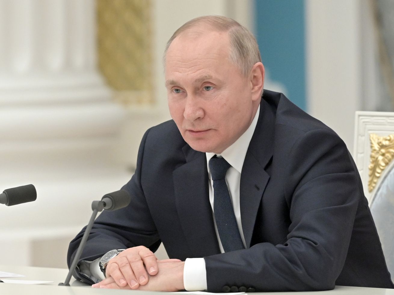 Vladimir Putin sits in a meeting.