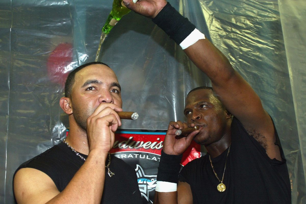 Shortstop Alex Gonzalez #11 of the Florida Marlins gets covered in beer by teammate second baseman Luis Castillo #1 after beating the San Francisco Giants in the 2003 National League Division Series at Pro Player Stadium