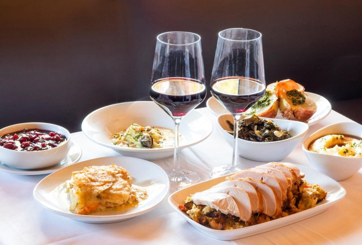 A table full of Thanksgiving dishes and glasses of wine at Jar restaurant in Los Angeles, California.