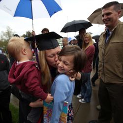Kim Reeves holds son Gunnar and kisses daughter Brooke as husband Jesse, right, looks on after the S.J. Quinney College of Law commencement ceremony at the University of Utah in Salt Lake City on Friday, May 11, 2018. Kim Reeves' son Austin is on the far left.